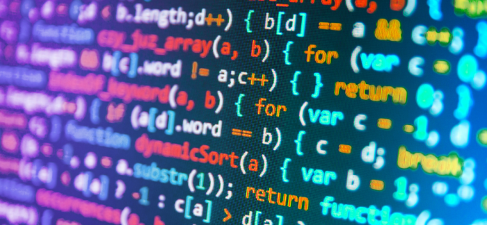 Close-up of a computer screen at a hackathon displaying colorful programming code, highlighting syntax in various colors like blue, purple, and green.